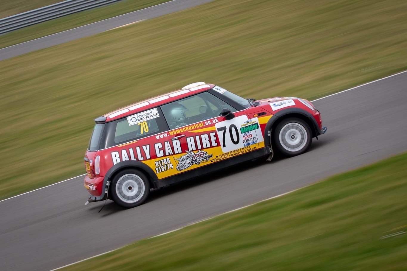 a mini rally car driving at high speed on track